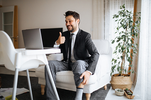 Man giving Thumbs Up to Laptop While Wearing Pajama Pants