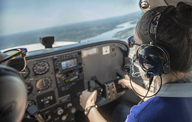 young pilot at the controls of a flying small airplane
