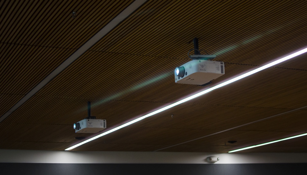 Two projectors hanging from ceiling