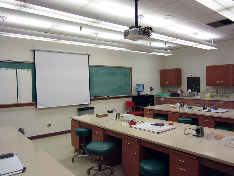A laboratory with workbenches and a projector